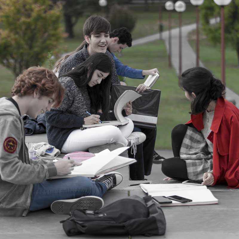 Alumnos dibujando en el campus